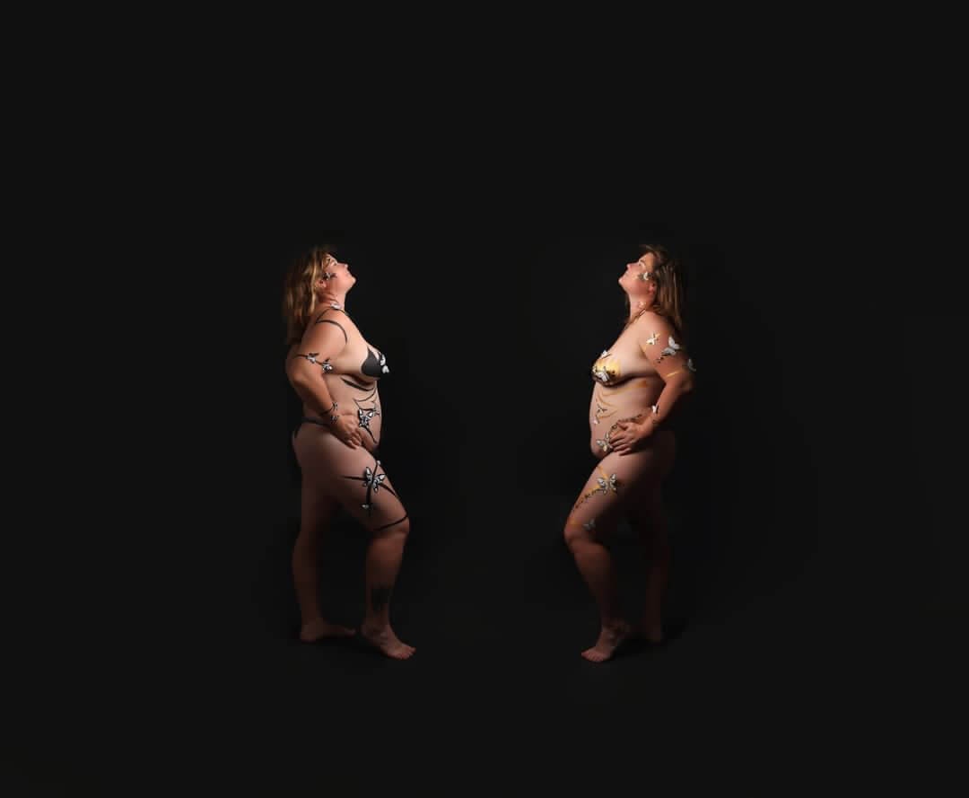 Deux femmes en profil, portant des bikinis et ornées de body art, se tenant avec confiance contre un fond noir.