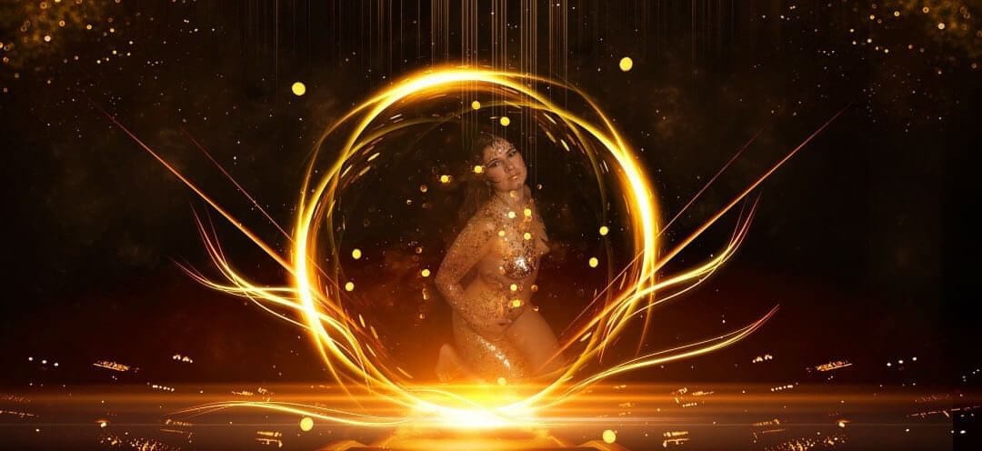 Une femme posée de manière créative contre un fond sombre, entourée d'effets lumineux dorés et oranges qui créent une atmosphère éthérée, évoquant une sensation de célébration ou de performance.