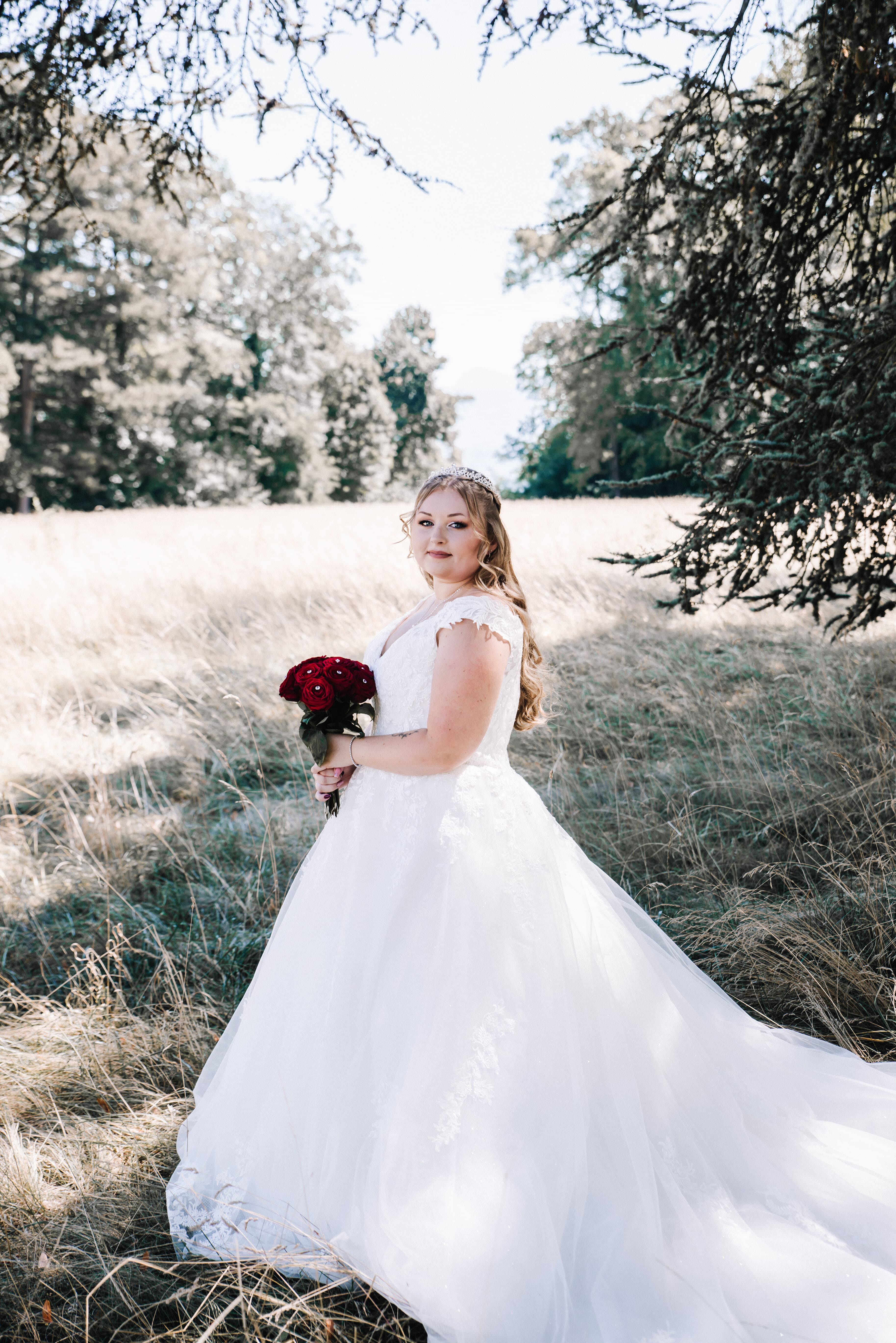 Un portrait rapproché d'une femme à la chevelure blonde ondulée, mettant en valeur son maquillage sophistiqué et son expression détendue arrière-plan flou avec des lumières bokeh chaudes.