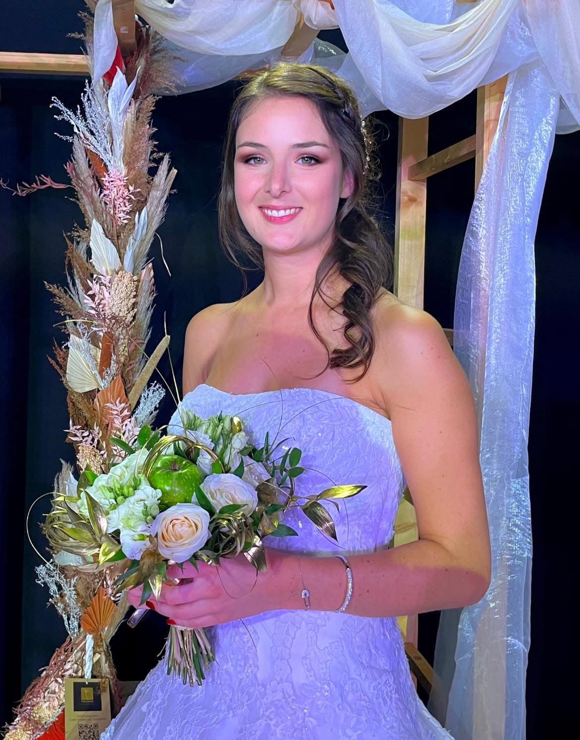 Une modèle se tient gracieusement sur le podium, mettant en valeur une robe de mariée éblouissante